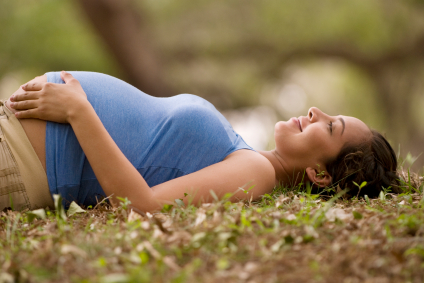 pregnant woman lying in grass nature