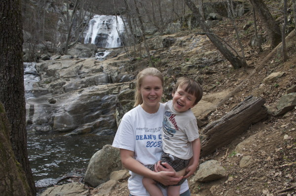 green mom and kid hiking in the woods